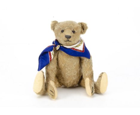 A Steiff teddy bear circa 1908, with golden mohair, black boot button eyes, pronounced muzzle, black stitched nose, mouth and