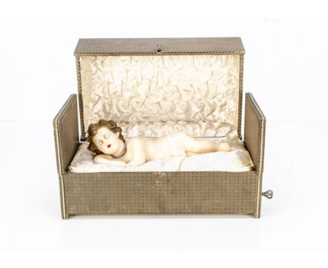 A early 20th century French wax Christ Child musical automaton,  of poured wax sleeping Jesus with moulded curly blonde hair,