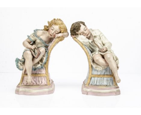 A pair of painted Parian sculptures of sleeping children by R J Morris,  each reclining on a gender specific upholstered chai