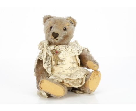 A 1950s Steiff teddy bear,  with beige mohair, clear and black glass eyes with brown packs, muzzle with brown stitched nose, 