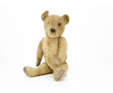 A 1930s Chiltern-type teddy bear, with golden mohair, one orange and black glass eyes, pronounced muzzle, black stitched nose