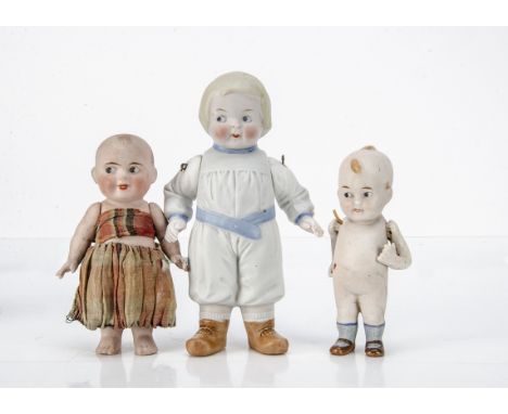Three all-bisque comic children,  the largest with moulded clothes, blue belt and shoes, blonde side parted hair, side glanci