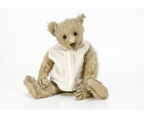 A Steiff teddy bear circa 1907,  with blonde mohair, black boot button eyes, pronounced clipped muzzle, black stitched nose, 