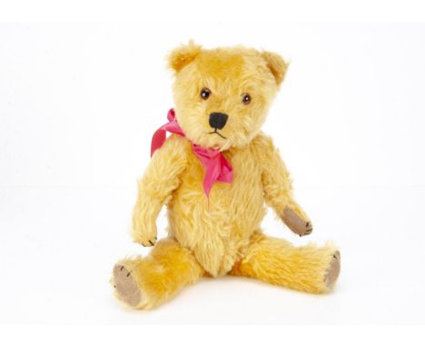 A post-war Chiltern Hugmee teddy bear,  with golden mohair, orange and black glass eyes, muzzle with black stitched nose, mou