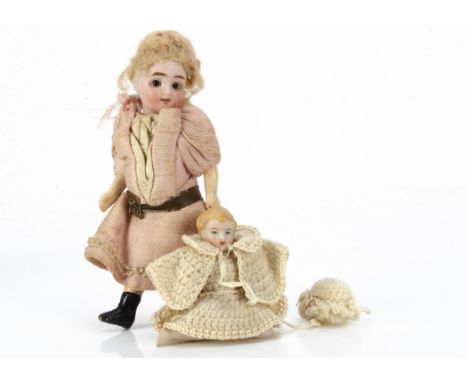 A German bisque headed dolls' house doll,  with dark glass eyes, blonde  mohair wig, jointed composition body and pink dress 
