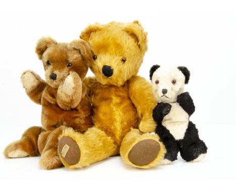 Two post-war British teddy bear pyjama cases,  a Merrythought golden mohair teddy bear with orange and black glass eyes, blac