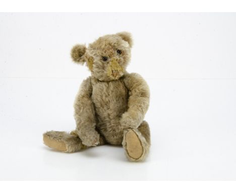 A Steiff teddy bear circa 1910, with blonde mohair, black boot button eyes, pronounced muzzle, swivel head, jointed elongated