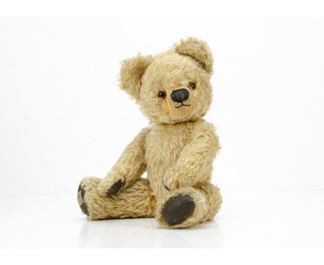 A 1950s Chad Valley teddy bear, with blonde mohair, replaced orange and black glass eyes, clipped muzzle, black stitched bulb