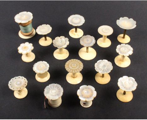 Thirteen mother of pearl top reels, a similar emery, tape measure, reduced tape, and a waxer, largest reel 3cm dia but most o