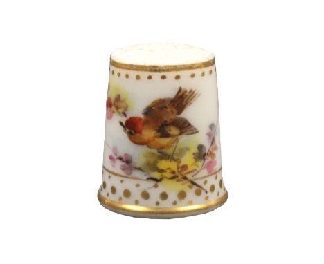 A Royal Worcester thimble painted with a bird on a flowering branch below a gilt band and dots and a frieze of three rows of 