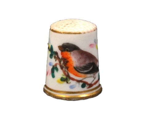 A 19th Century English porcelain thimble attributed to Worcester painted with a bird on a flowering branch between gilt lines