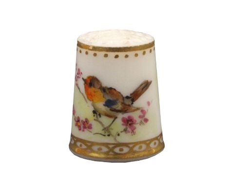 A Worcester porcelain thimble painted with a bird on a flowering branch below a line and gilt dot border, the frieze with gil