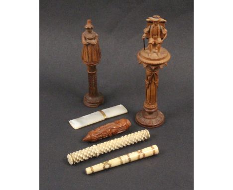 Five needlecases, comprising two Tyrolean standing figural carved examples, largest 13cm, both s.d., an ivory stacked brick c