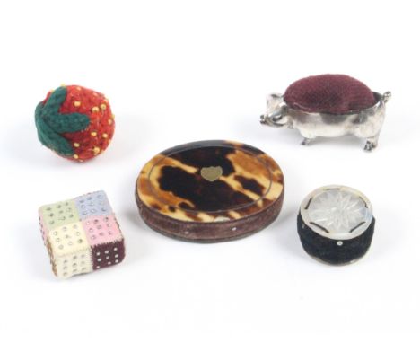 Five pincushions and emeries comprising a good pin stuck patchwork example, 2cm sq., an oval tortoiseshell example with metal