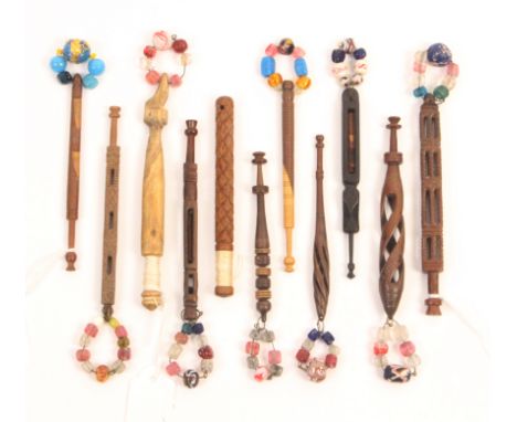 Eleven 19th Century wooden lace bobbins mostly carved, comprising an ebony example with bitted babe, another with babe below 