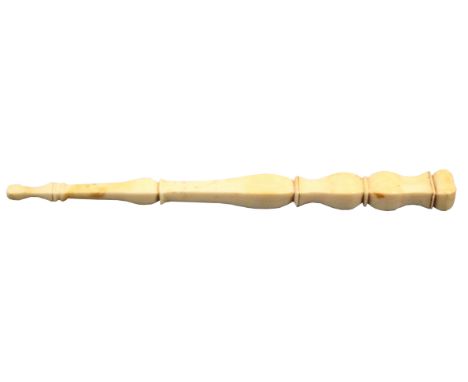 A 19th Century ivory knitting stick, probably French, of square section carved with balusters, 19cm