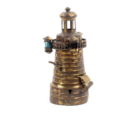 A gilt brass novelty tape measure in the form of a lighthouse, complete printed tape in ins and cm, a little frayed at start,