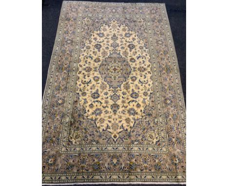 A fine Kashan rug / carpet, woven in muted tones of grey, blue, and cream, 310cm x 205cm. 