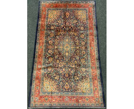 A Persian Sarough rug / carpet, having a diamond shaped medallion within a central field densely woven with stylised floral m