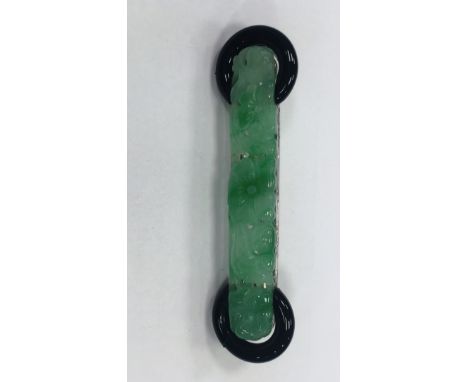 ART DECO JADEITE BROOCH
with a long section of jadeite carved with a floral design, with two black enamelled hoops at each en