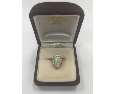 OPAL AND DIAMOND CLUSTER RING set with a central oval cabochon opal measuring 12.6 x 6.41mm, surrounded by brilliant cut diam
