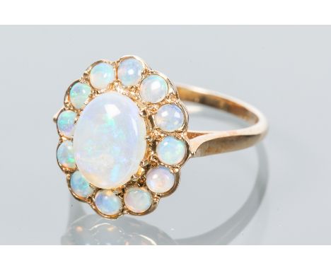 OPAL CLUSTER RING
the central oval cabochon cut opal surrounded by smaller cobochon cut opals, marked nine carat gold, size O