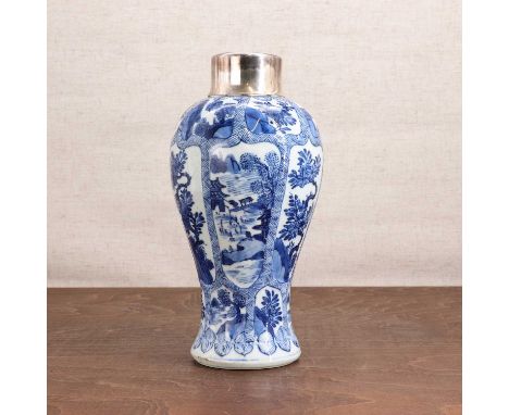 A Chinese blue and white vase, Kangxi (1662-1722), of baluster form, painted with a landscape or flowers in shaped panels, th