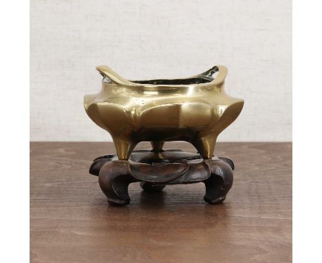 A Chinese bronze incense burner,Qing dynasty (1644-1911), of compressed lobed form on three stud feet, flanked with two loop 