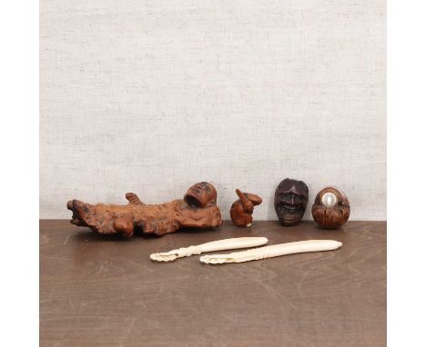 A Japanese root carving,19th-20th century, with a monk holding a double gourd in his left hand,16cm long, two netsuke,of a bo