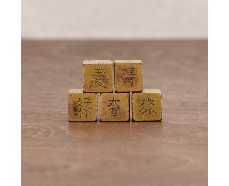 A collection of five gilt-bronze game dice, possibly for a drinking game, each side inscribed with two characters, 1.5cm long