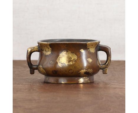 A Chinese gilt-bronze incense burner,the compressed globular body rising from a flared foot, flanked by two loop handles to e