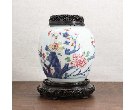 A Chinese famille rose jar and cover, 18th century, of ovoid form, painted with peony and blossoming prunus by a rock, 24cm h