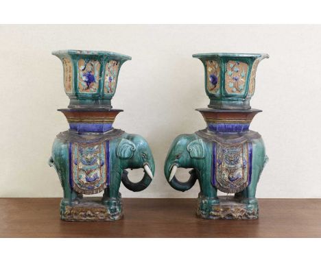 A pair of Chinese Shiwan ware jardinières, Republic period (1912-1949), each in the shape of an elephant, standing on an oval