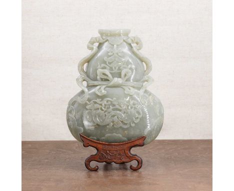 A Chinese jade wall vase,18th century, in the shape of a compressed double gourd with a flat back, carved with a twin fish am