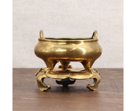 A Chinese bronze incense burner,Qing dynasty (1644-1911), the compressed globular body rising from three stud feet with two l