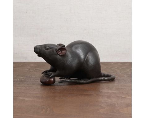 A Japanese bronze okimono,Meiji period (1868-1912), of a rat holding a nut in its front paws, its long tail curled around to 