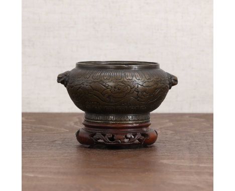 A Chinese bronze incense burner,Qing dynasty (1644-1911), of compressed globular form on a circular foot, incised with mythic