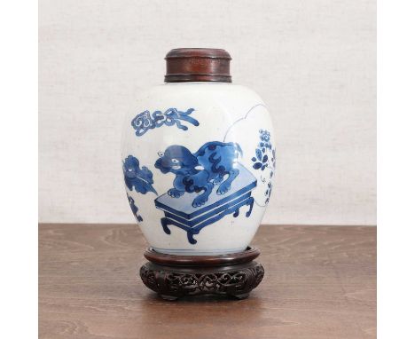 A Chinese blue and white jar,Kangxi (1662-1722), of ovoid form, painted with precious objects, 14cm high, with associated woo