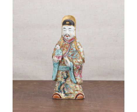 A Chinese famille rose figure,19th century, of Fu Lao wearing a long robe, standing with a boy resting in his right arm, elab