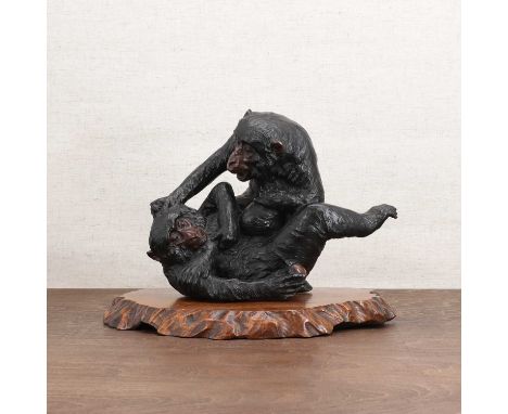 A Japanese bronze okimono, Meiji period (1868-1912), naturalistically cast with two monkeys wrestling over a leafy biwa fruit