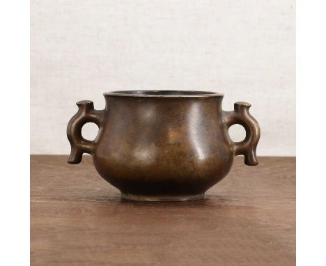 A Chinese bronze incense burner,the heavily cast, bulbous body raised on a circular foot, tapering towards the waisted neck, 