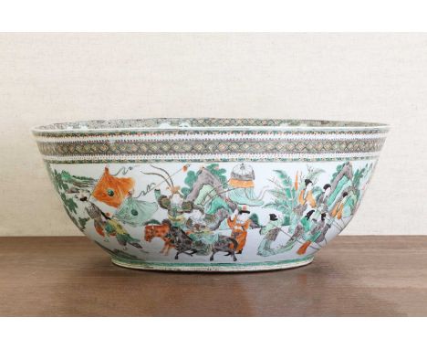 A large Chinese famille verte punchbowl,19th century, finely painted with figures on horseback in a battle scene, in shaped p