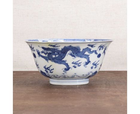 A Chinese blue and white bowl,Kangxi (1662-1722), the rounded sides rising from a circular foot to a flared rim, painted with