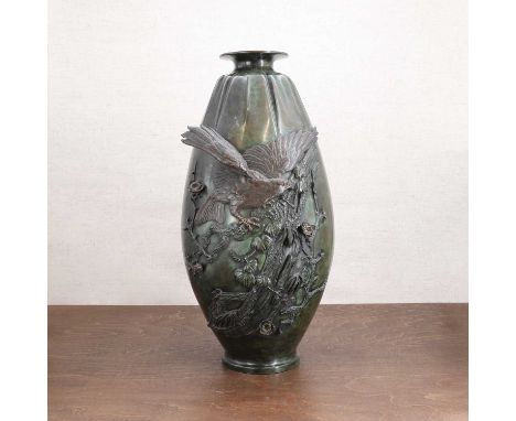 A Japanese bronze vase,early 20th century, of olive form on a circular base with a flared rim, decorated in relief with an ea