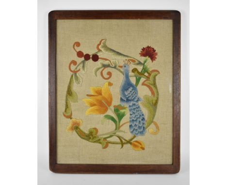 An Arts & Crafts raised wool work panel decorated with a stylised peacock, tulips and Carnations, in contemporary oak frame, 