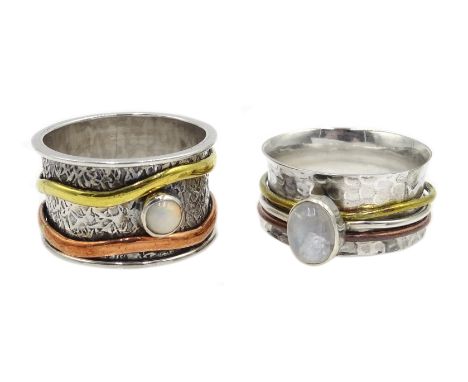 Two silver spinner rings set with a moonstone and an opal, stamped Sil Condition Report One ring is size W-X and has a depth 