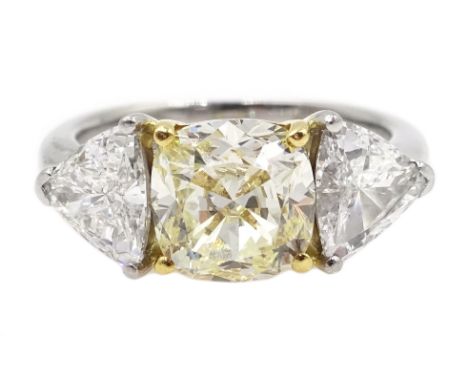 Platinum three stone diamond ring, the centre fancy light yellow cushion cut diamond of approx 1.70 carat with two white tril