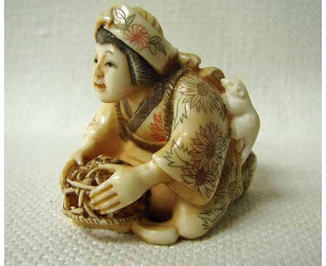 A fine Japanese ivory Netsuke, late 19th/early 20th century, a seated lady holding a basket catching rats, a rat on her back,