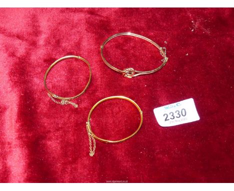 A rolled gold Bangle with knot detail and two small gold plated Lagarmic bangles.