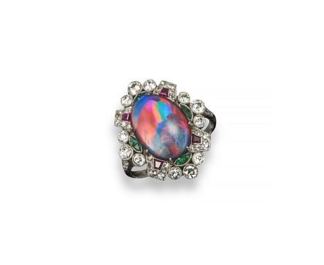 An Edwardian opal and gem set cluster ring, the oval-shaped solid black opal is set within a surround of graduated circular c